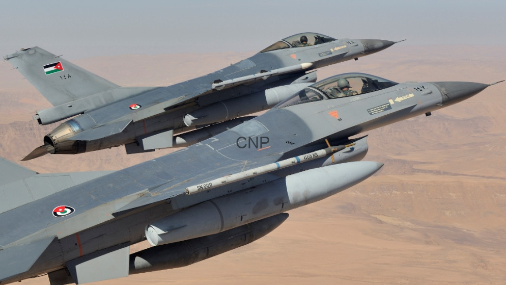 image - Center News Network Two two-seat fighter jets in formation flying over a desert, armed with missiles under their wings
