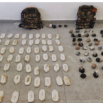 Law enforcement drug seizure: numerous white brick-shaped packages laid out in neat rows on a tiled floor, with two camouflage backpacks above and smaller bags to the right.