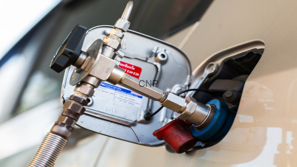 image - Center News Network Fuel pump nozzle inserted into a car's fuel filler neck during refueling at a gas station