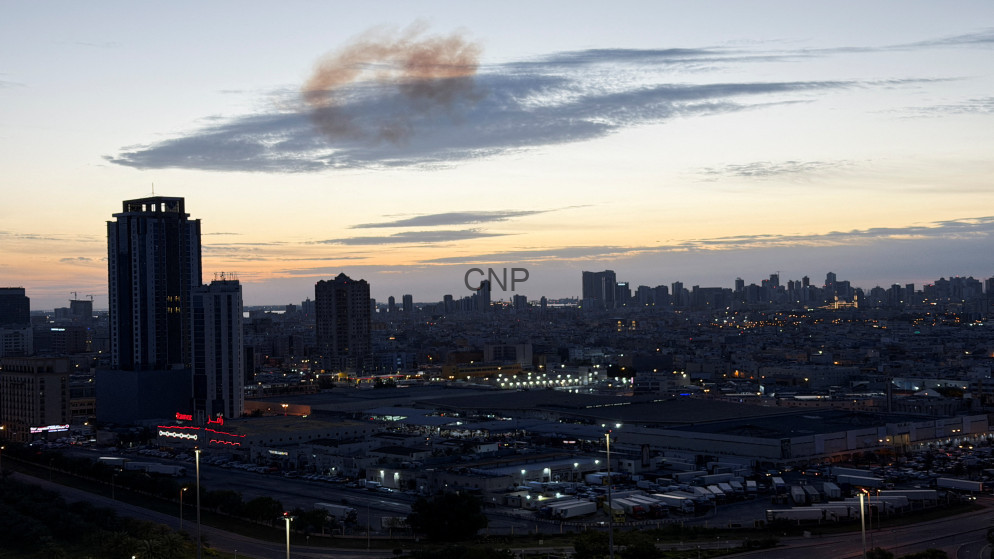 image - Center News Network Dusk city skyline with tall buildings and an industrial foreground under a orange-blue sunset.