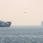 Hazy seascape with a large ship on the left and a smaller vessel on the right, a single bird in the sky, and a centered 'CNP' watermark.