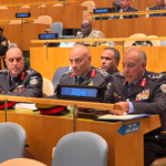 Row of high-ranking military officers in dress uniforms seated at a conference desk, 'JORDAN' nameplate in front of the central officer, badges and ribbons visible.