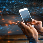 Hands holding a smartphone surrounded by glowing blue and orange network lines and particles.