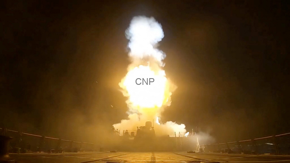 image - Center News Network Rocket engine test firing on a ground stand at night with a large bright exhaust plume and surrounding equipment.