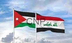 Jordan and Iraq flags waving side by side in a cloudy sky.