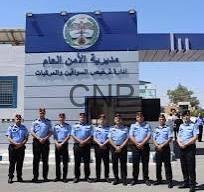 tarkh - Center News Network Line of uniformed police officers standing in a row outside a blue-and-white building with Arabic signage and a crest above the entrance.