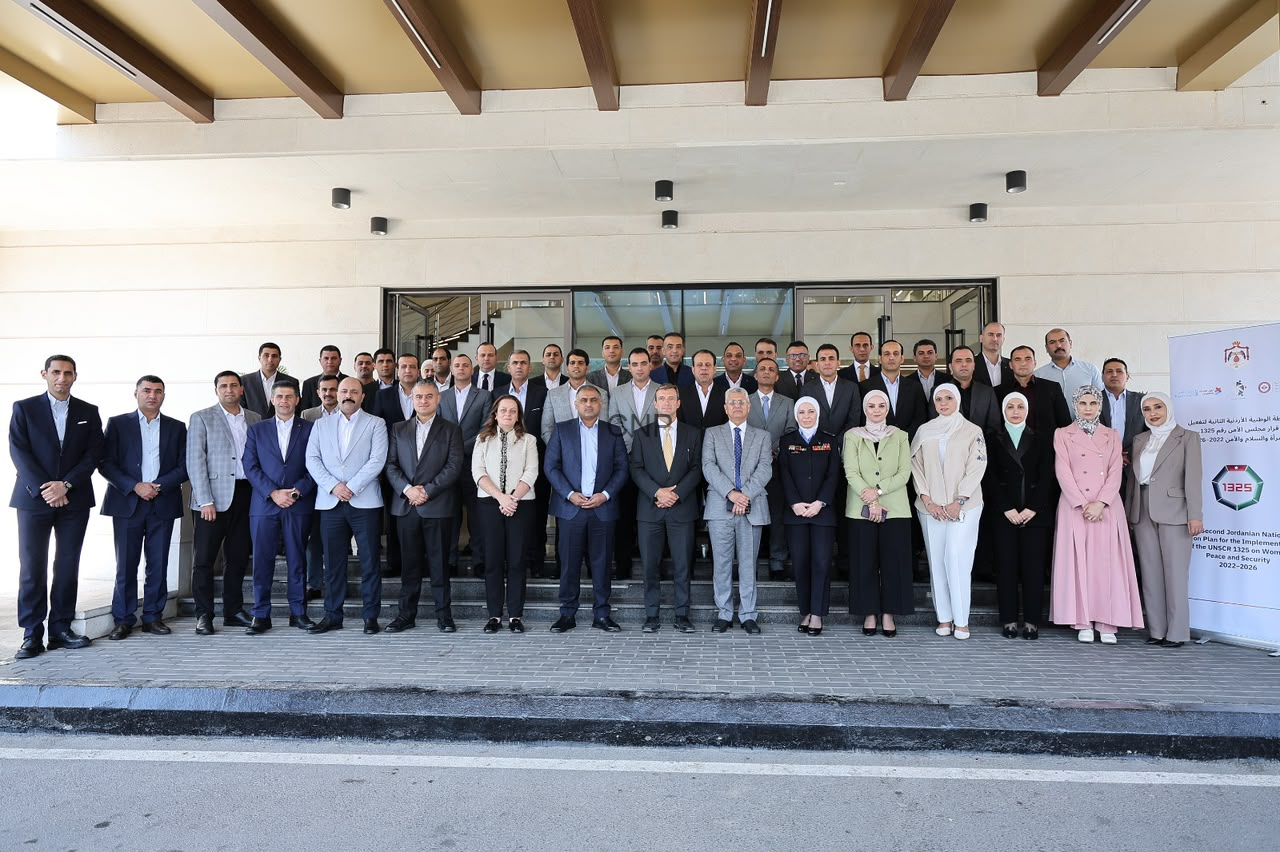 image - Center News Network Large group of professionals in formal attire posing on steps outside a building entrance for a group photo. On the right, a banner stands beside the group.
