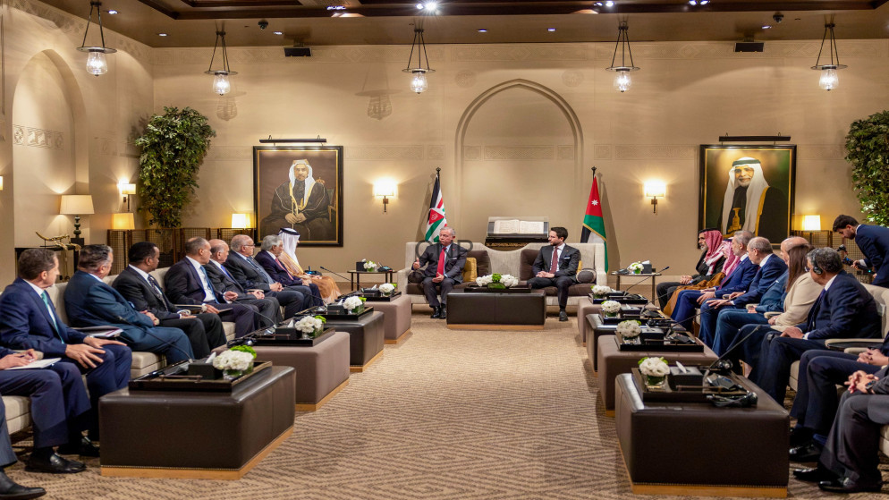 image - Rakeen News Diplomatic meeting in a beige, opulent room with two leaders seated center, flags behind them, and delegates on both sides.