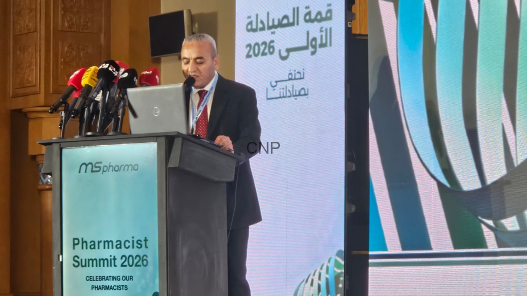 Man in suit speaks at a podium with multiple microphones during Pharmacist Summit 2026, MSpharma branding visible on the lectern.