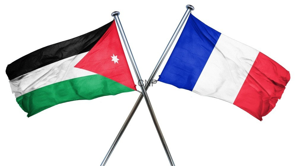 Two crossed flagpoles display the Jordanian flag on the left and the French flag on the right, symbolizing a flag display or diplomacy.